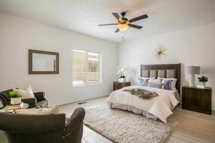 A bedroom with a bed , chair , and ceiling fan.