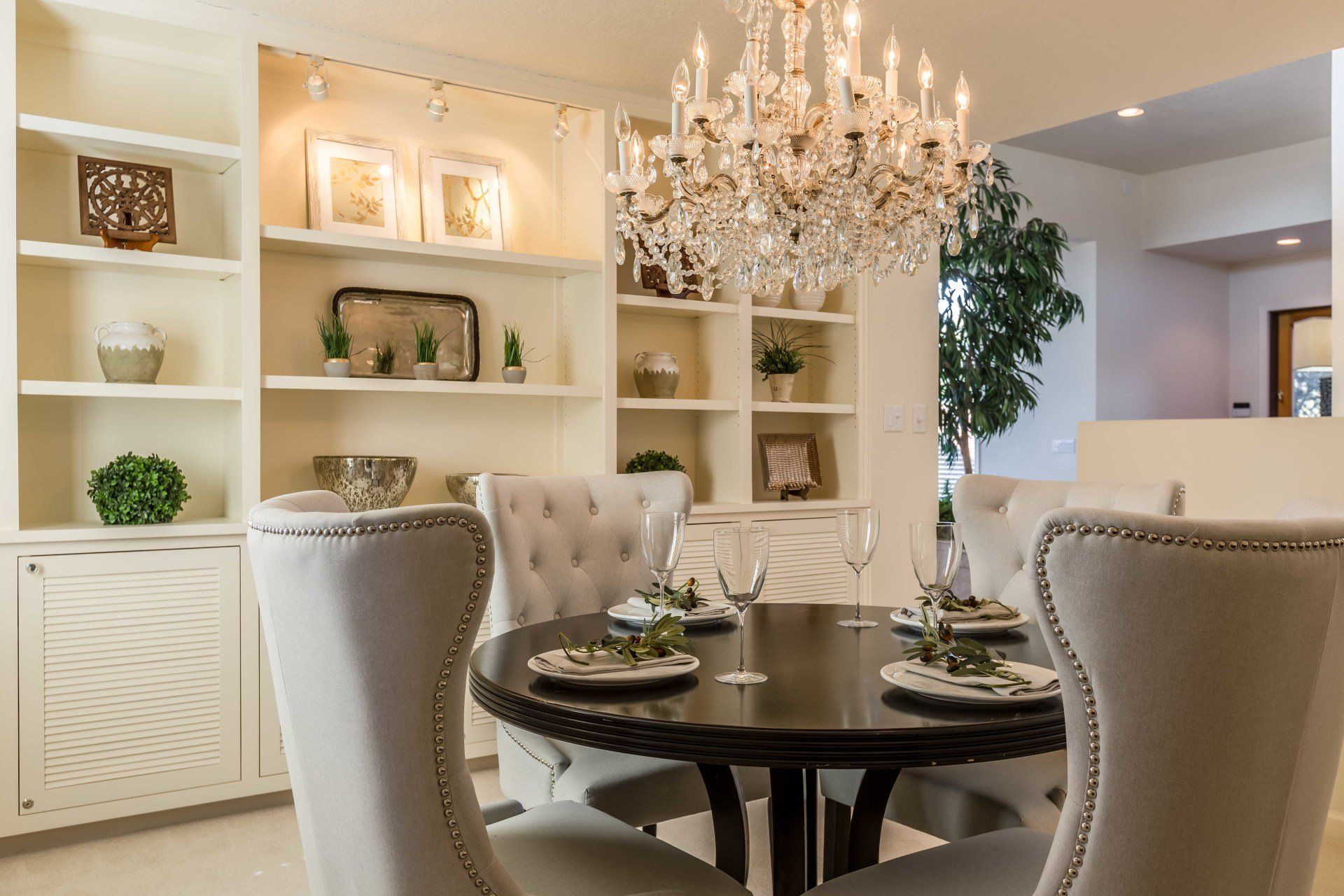 A dining room with a table and chairs and a chandelier.