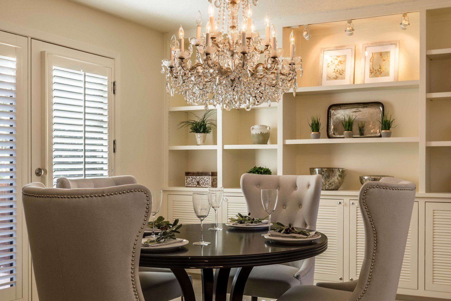 A dining room with a table and chairs and a chandelier.