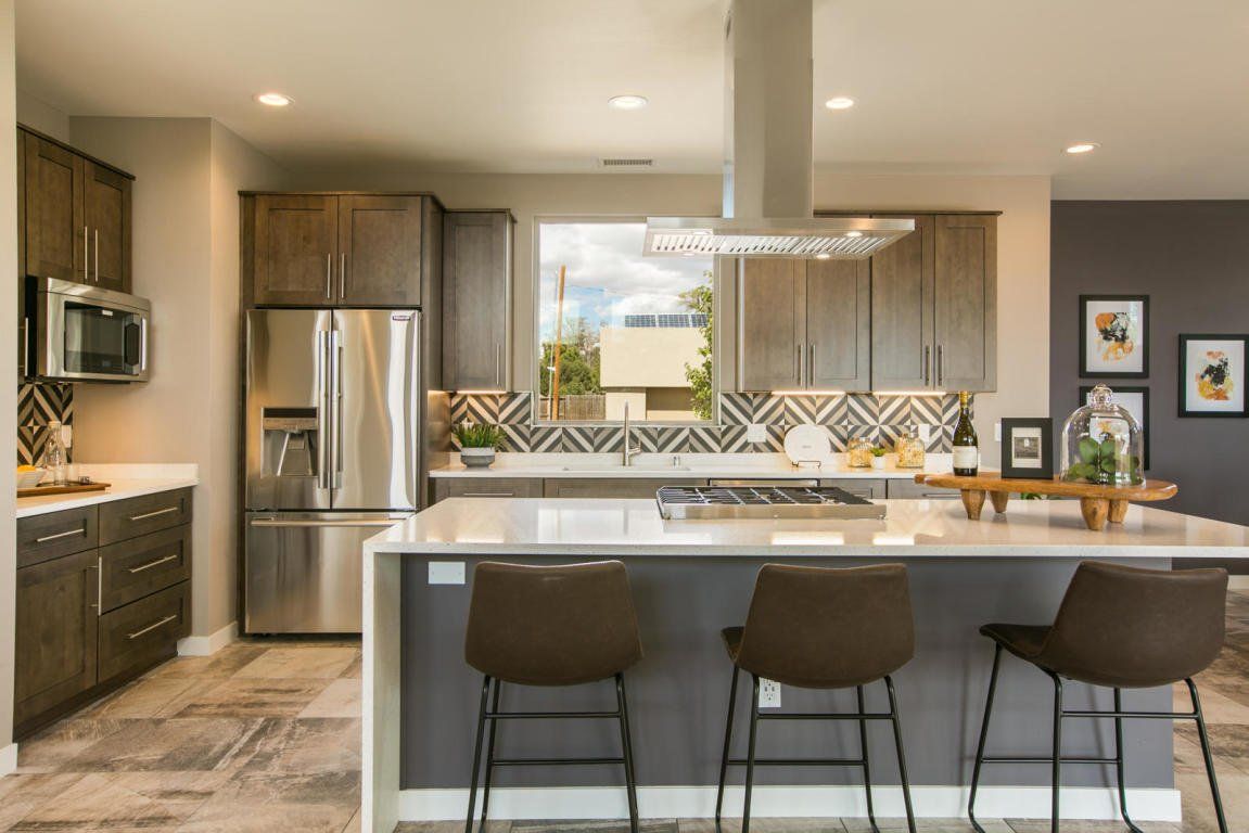 A kitchen with stainless steel appliances and a large island.
