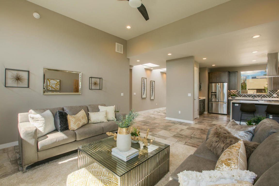 A living room with a couch , coffee table and ceiling fan.