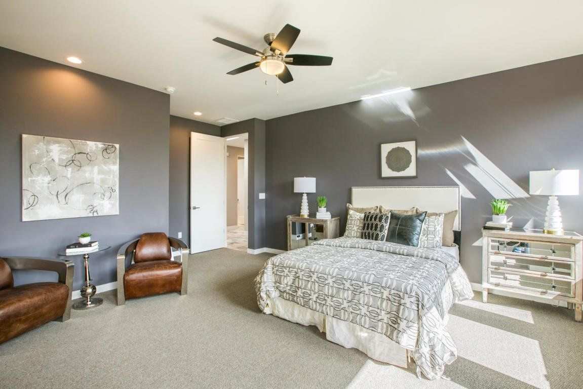 A bedroom with a large bed and a ceiling fan