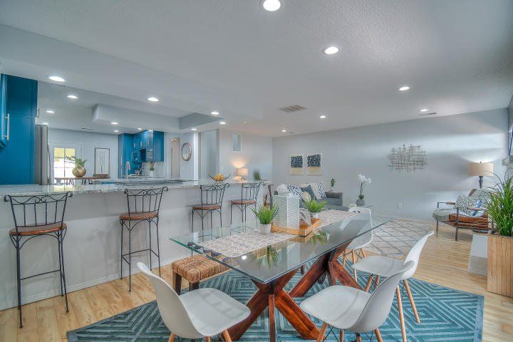 A dining room with a glass table and chairs in a house.