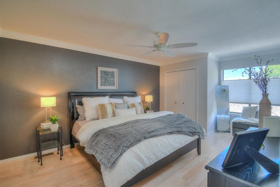 A bedroom with a large bed and a ceiling fan