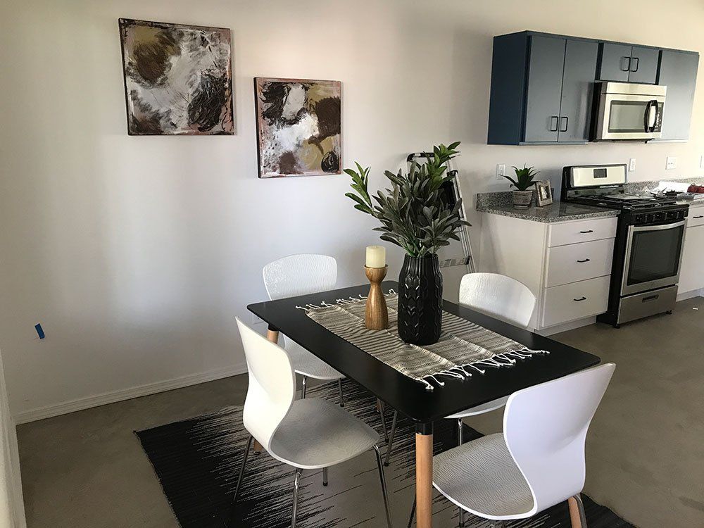 A kitchen with a table and chairs and a microwave.