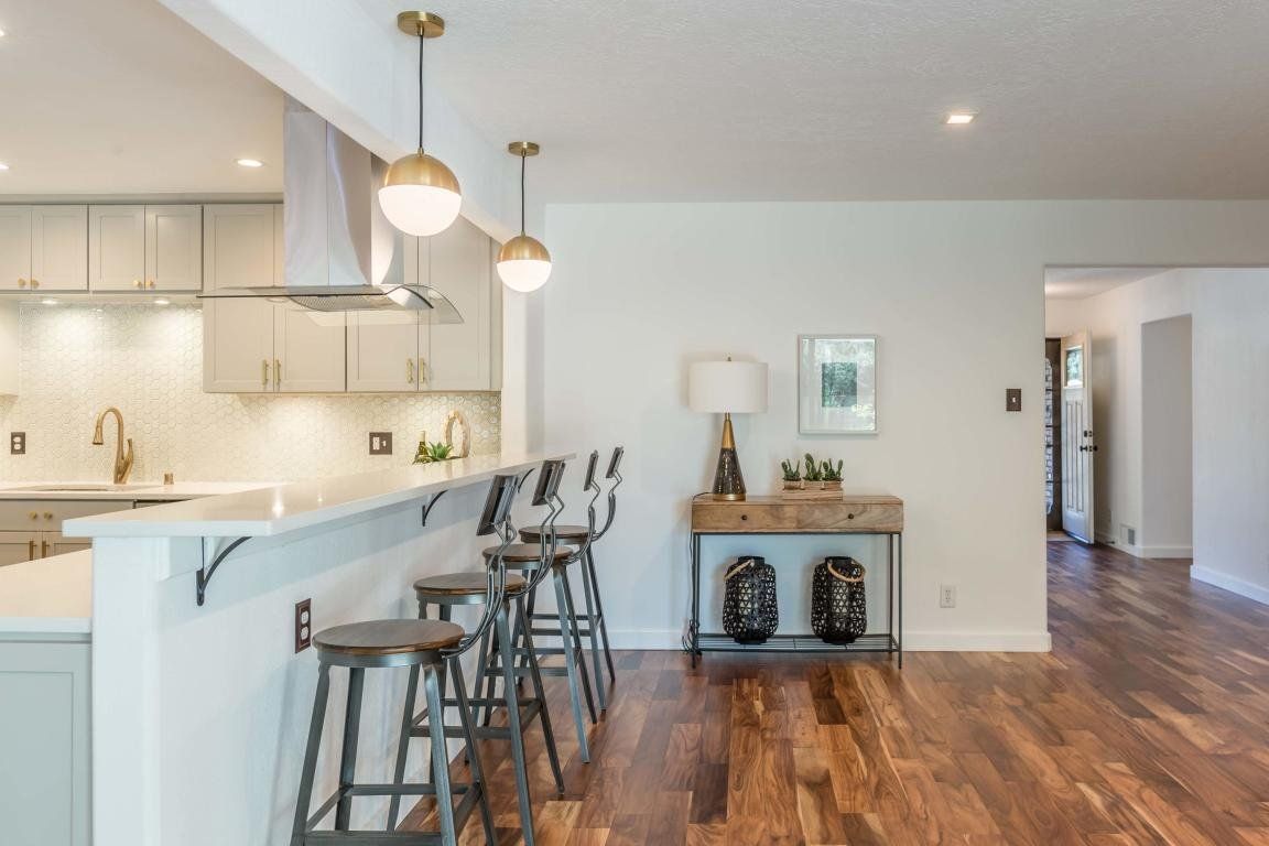 A kitchen with a bar and stools in it