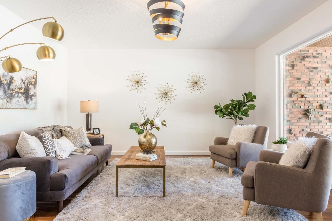 A living room with a couch , chairs , and a coffee table.