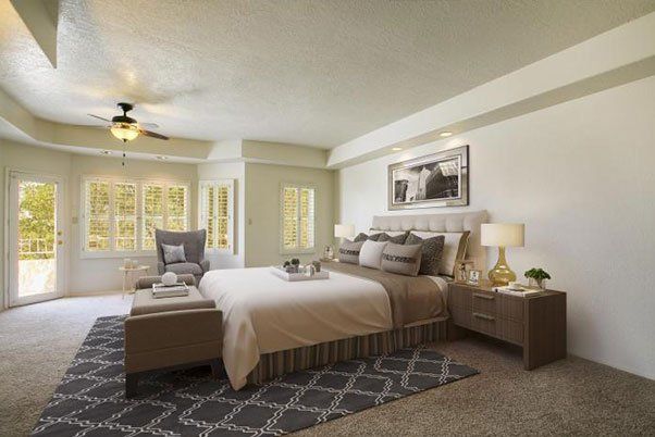 A bedroom with a large bed and a ceiling fan