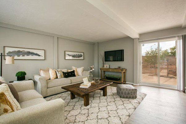 A living room with a couch , chair , coffee table , fireplace and television.