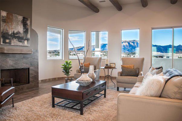 A living room with a couch , chairs , coffee table and fireplace.