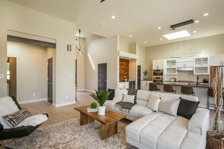 A living room with a couch , chair , coffee table and kitchen.
