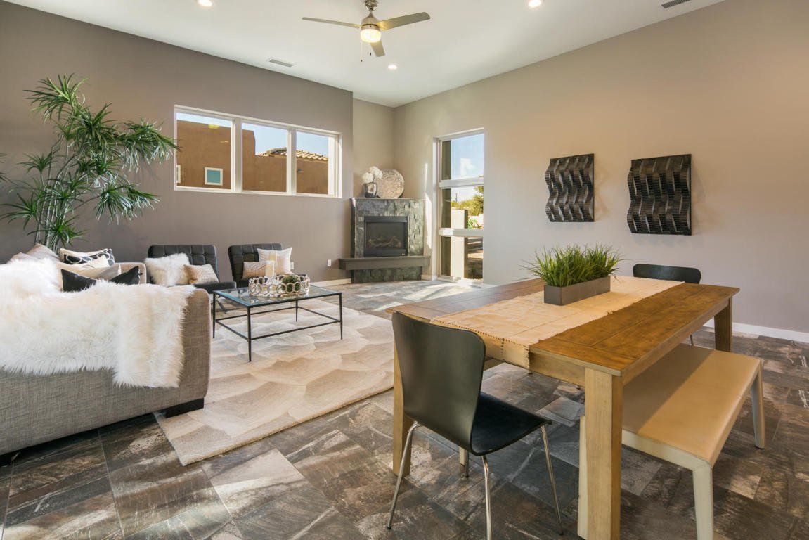 A living room with a table and chairs and a ceiling fan.
