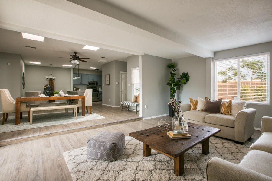 A living room with a couch , coffee table , chairs and a table.