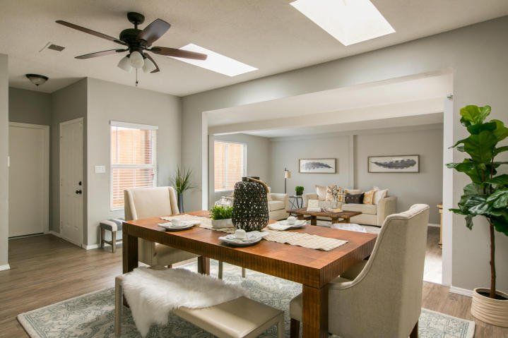 A dining room with a table and chairs and a ceiling fan.