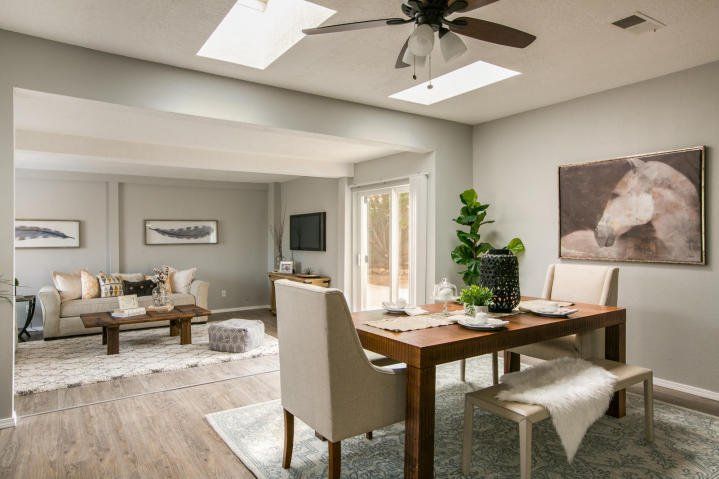 A dining room with a table and chairs and a ceiling fan.