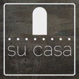 The logo for su casa is on a concrete surface.