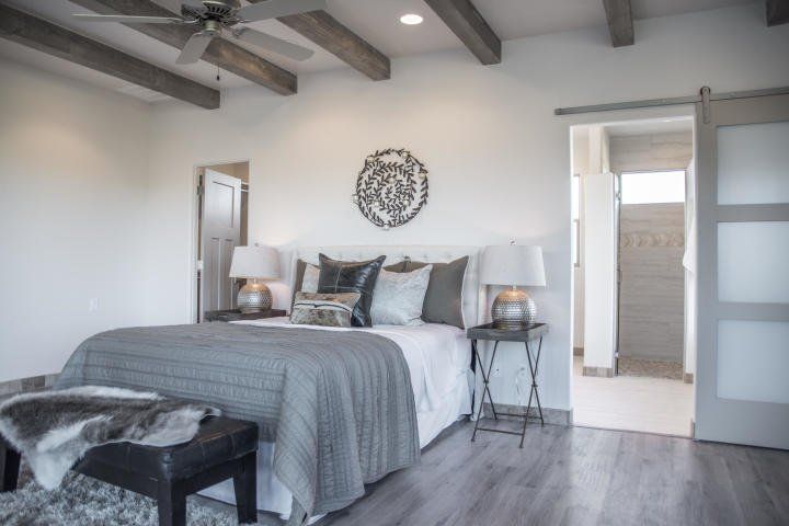 A bedroom with a large bed and a ceiling fan