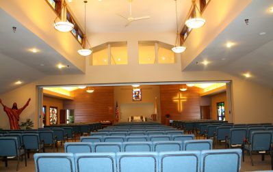 View of Country Manor Chapel from the back. Blue seats and a cross on the wall