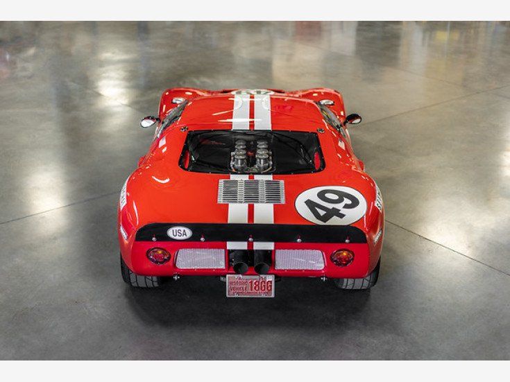 A red race car with the number 49 on the back is parked in a garage.