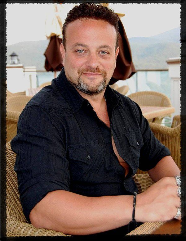 A man in a black shirt is sitting in a chair