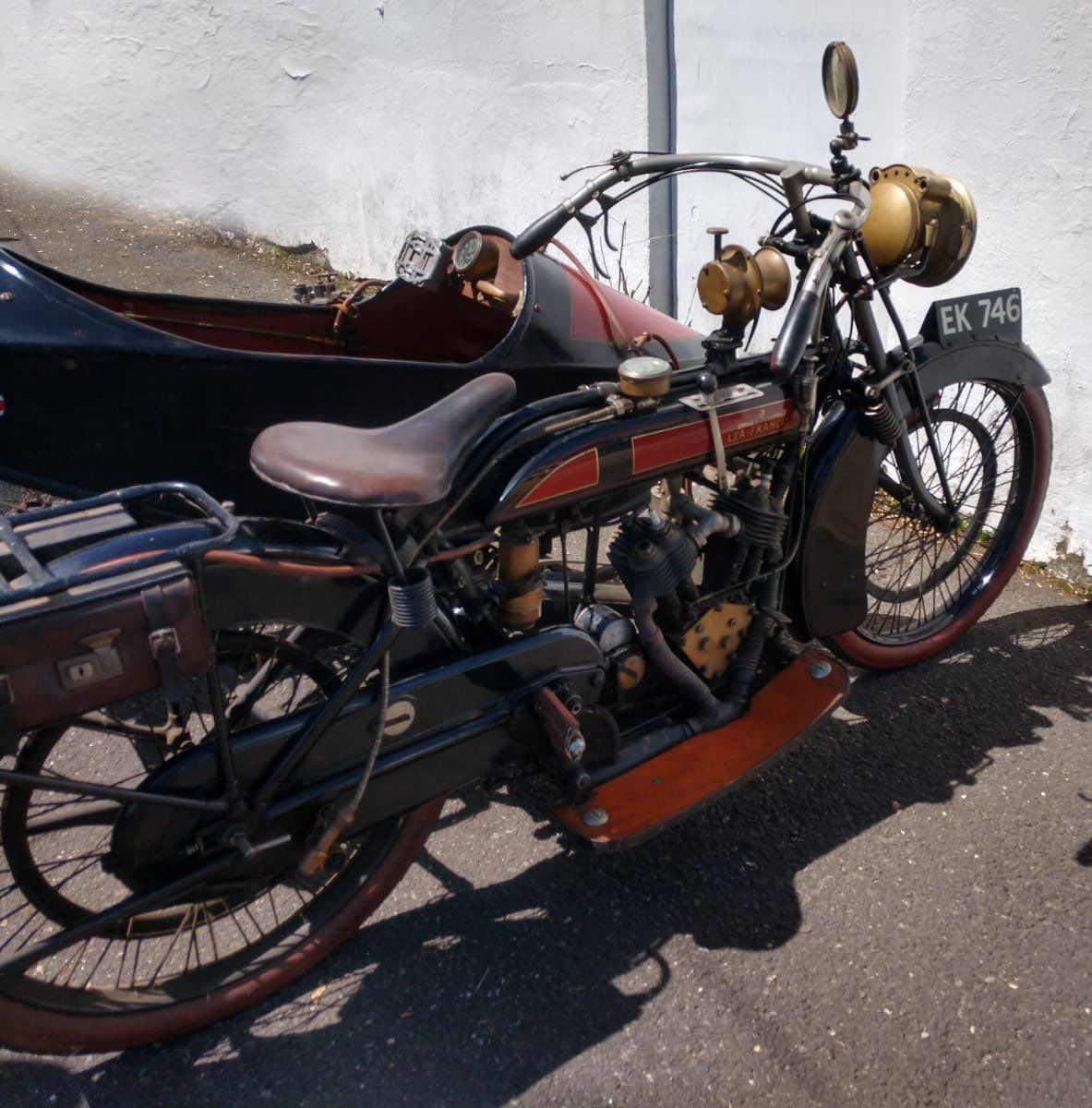 A motorcycle with a sidecar has a license plate that says ek 746