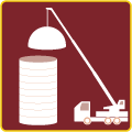 A crane is lifting a dome over a stack of cylinders.