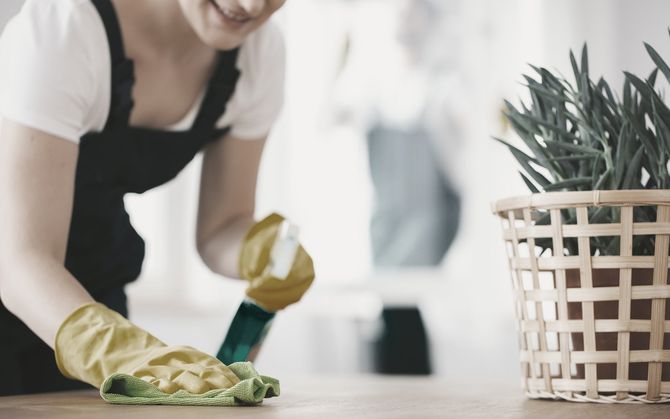 Woman with gloves wiping down table