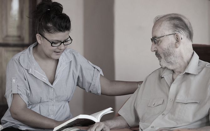 Woman reading to older man