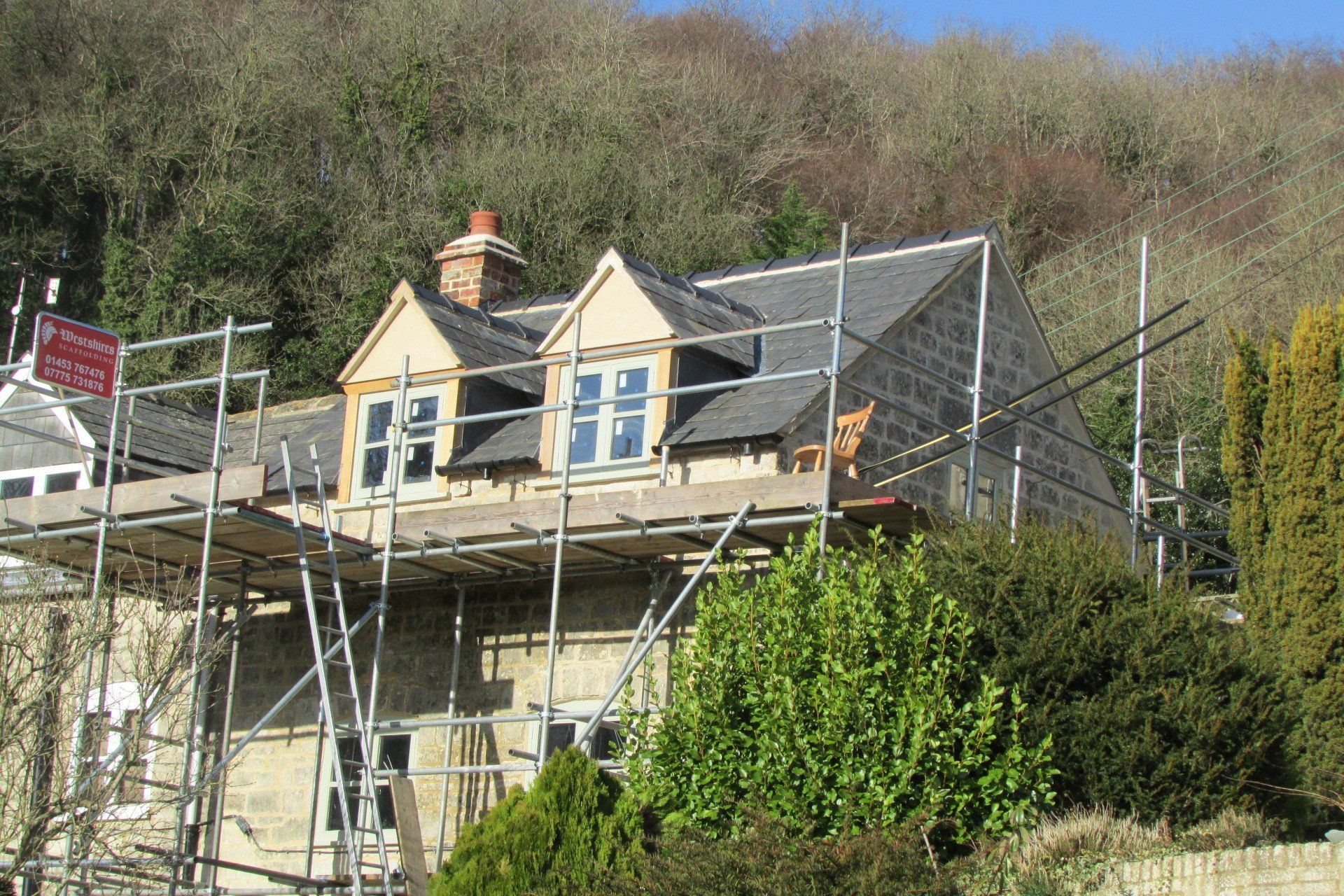 A house is being built on a hill with scaffolding around it.