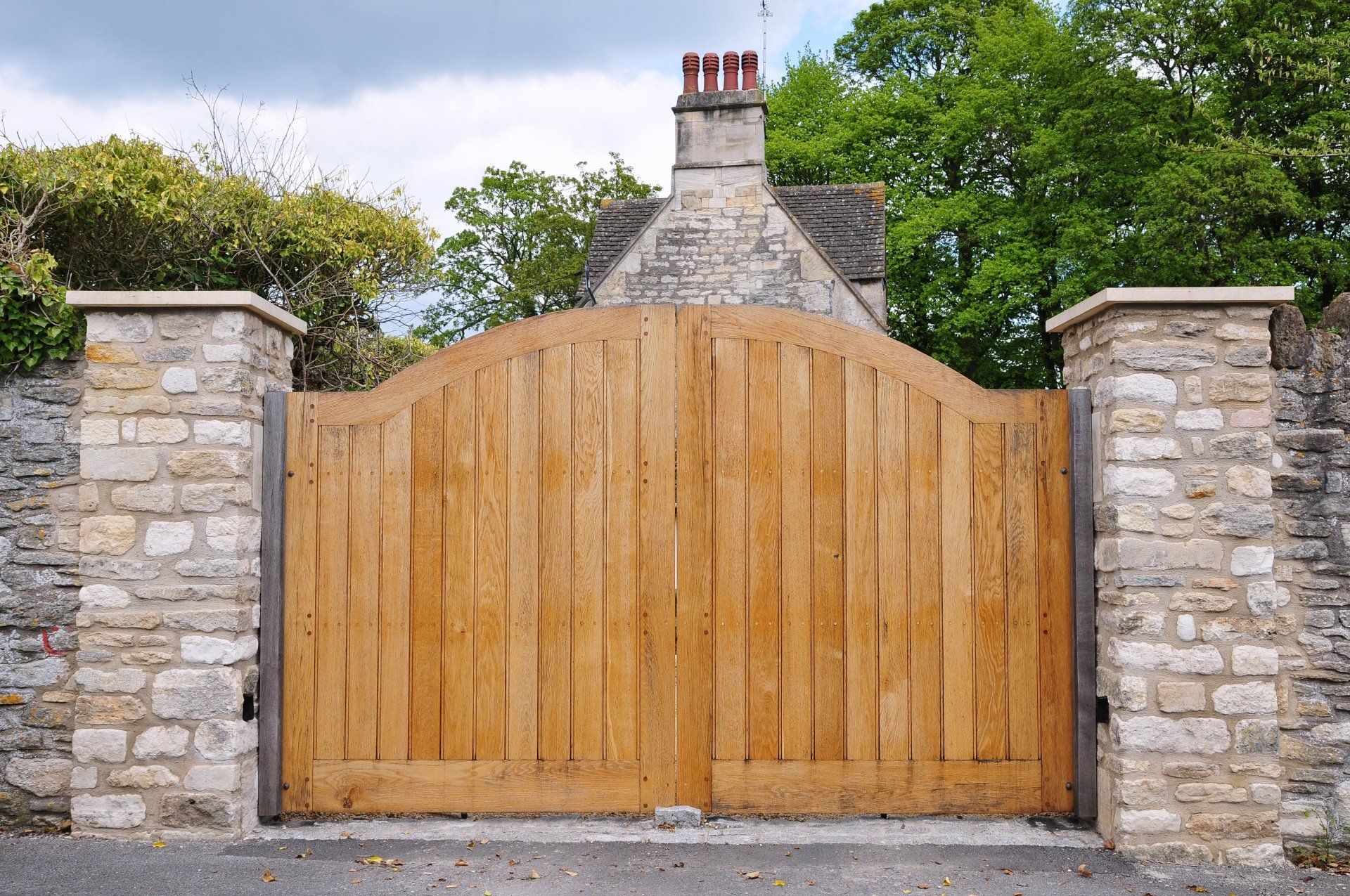 A wooden gate is sitting in front of a stone wall.