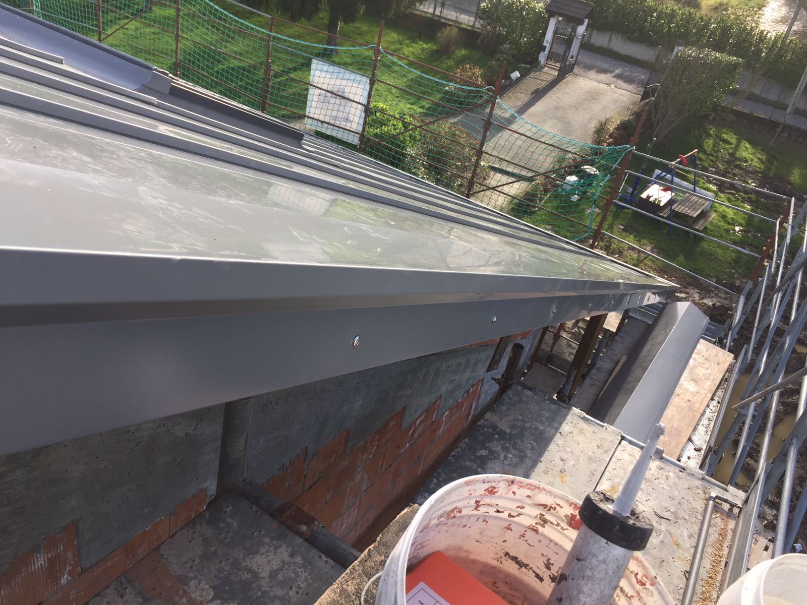 Un secchio di vernice è appoggiato sul tetto di un edificio.