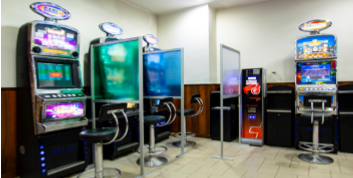 Una stanza piena di slot machine e sgabelli.