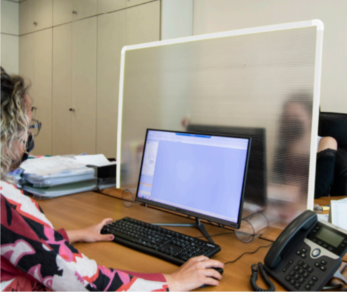 Una donna è seduta a una scrivania con un computer e un telefono