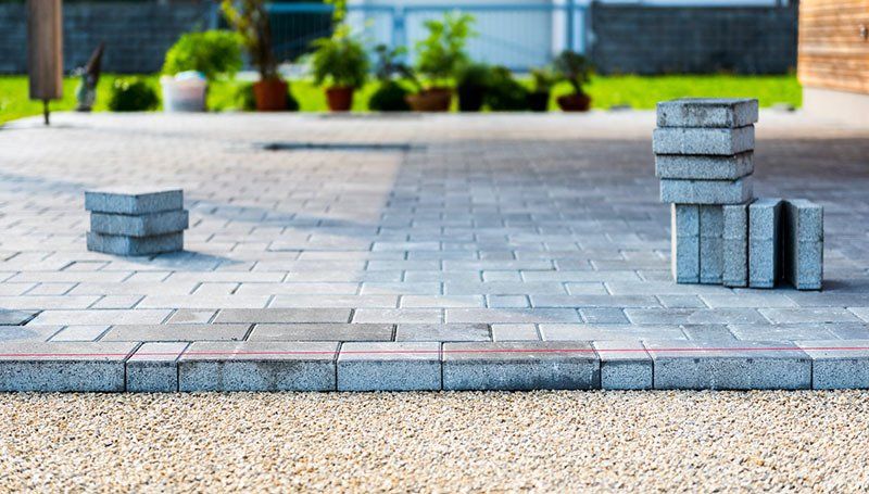 Laying Gray Concrete Paving Slabs — Lynams Landscapes In Jensen QLD Laying Gray Concrete Paving Slabs — Lynams Landscapes In Jensen QLD