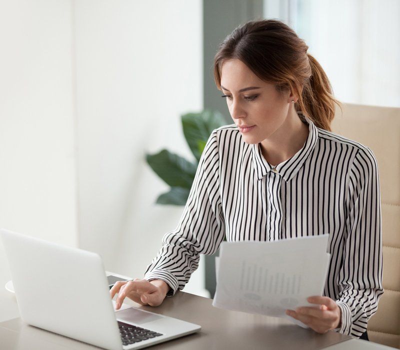 Serious Businesswoman Typing on Laptop — Toledo, OH — Margie's Cleaning & Liquidations
