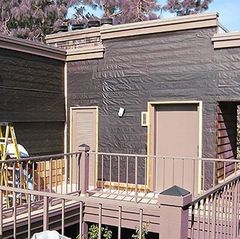 A house with a balcony and a ladder in front of it