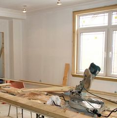 A circular saw is sitting on a wooden table in front of a window