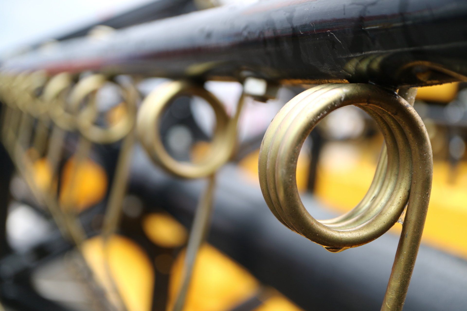 A close up of a wrought iron railing with a yellow background