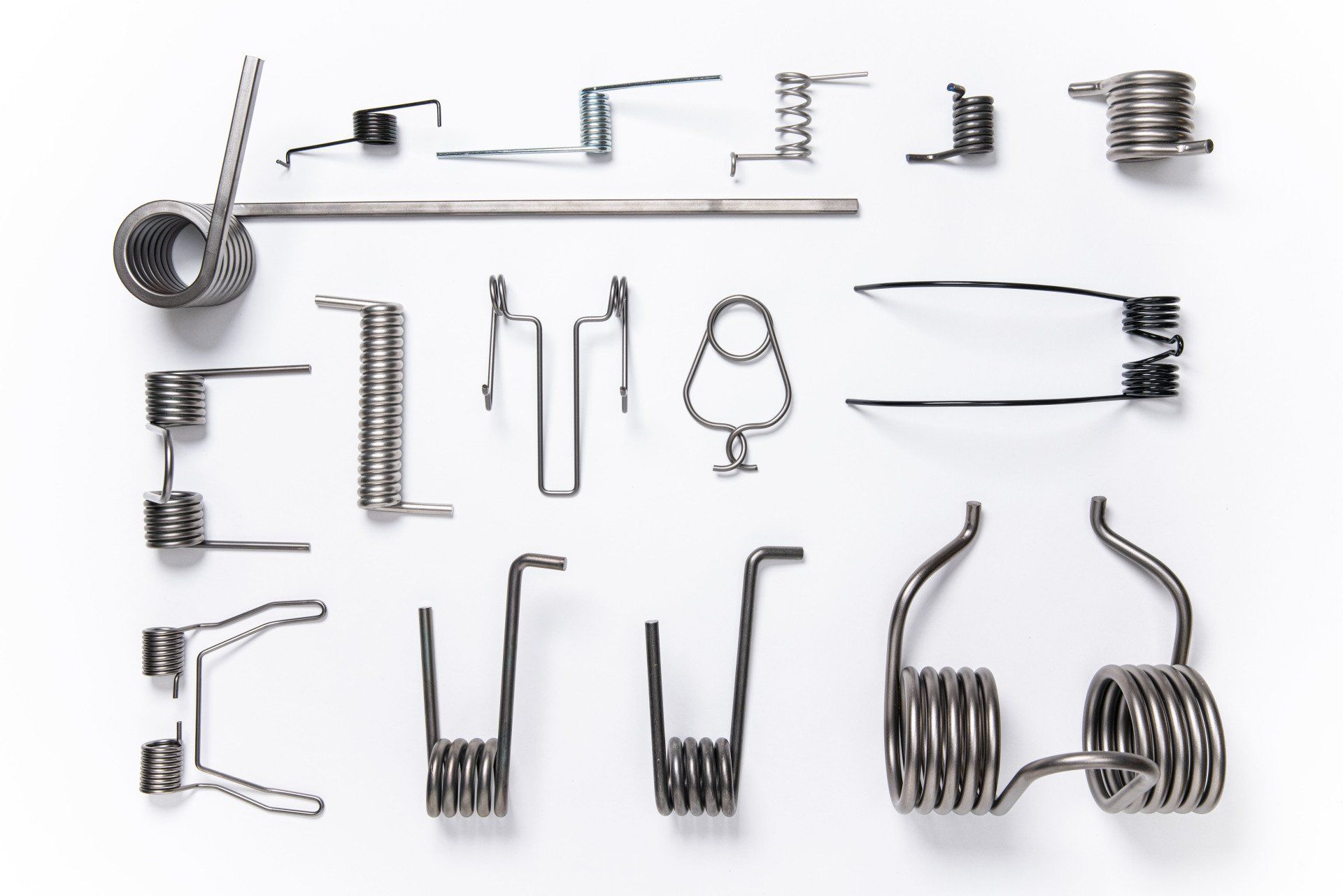 There are many different types of springs on a white surface.