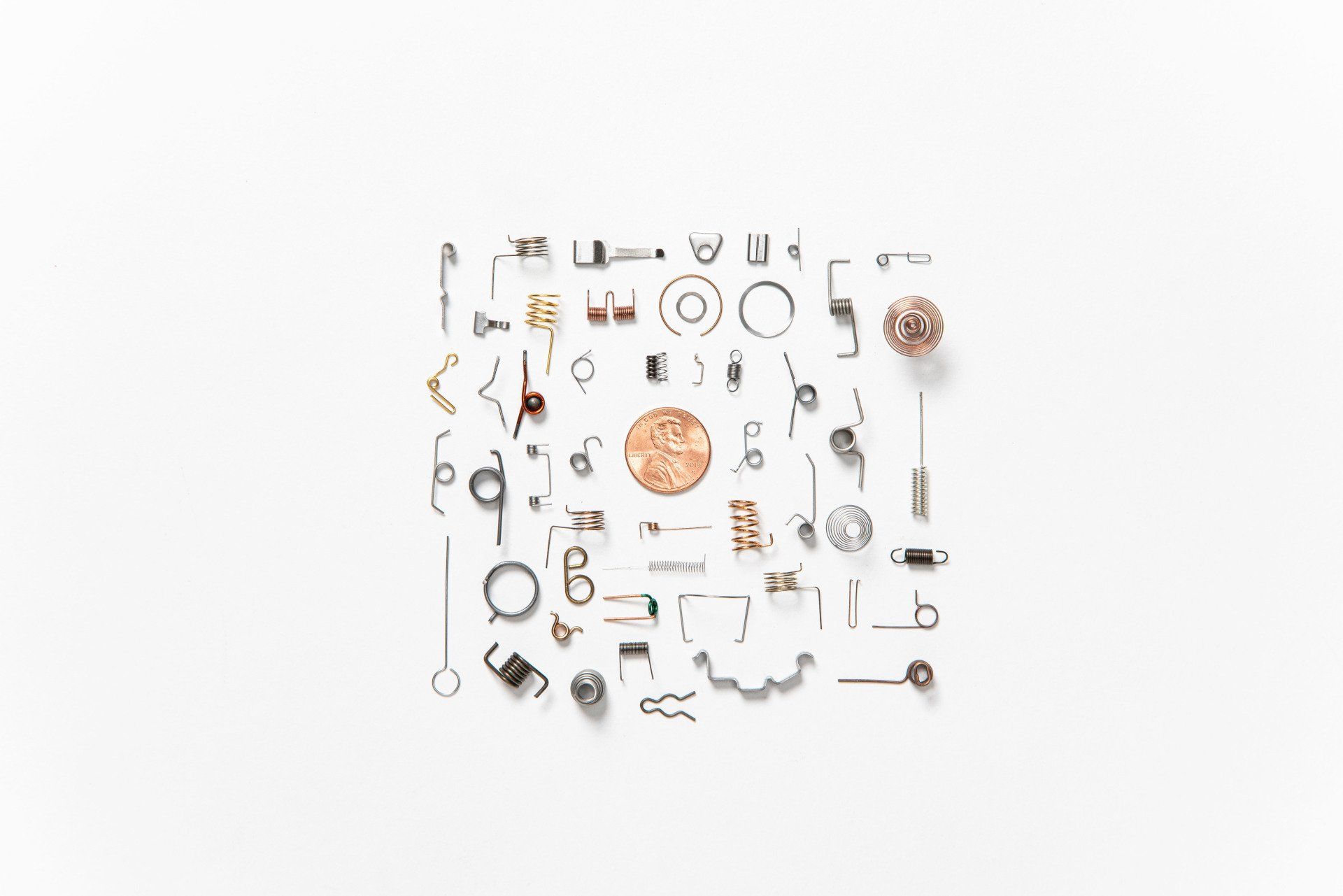 A bunch of different types of metal parts on a white background.