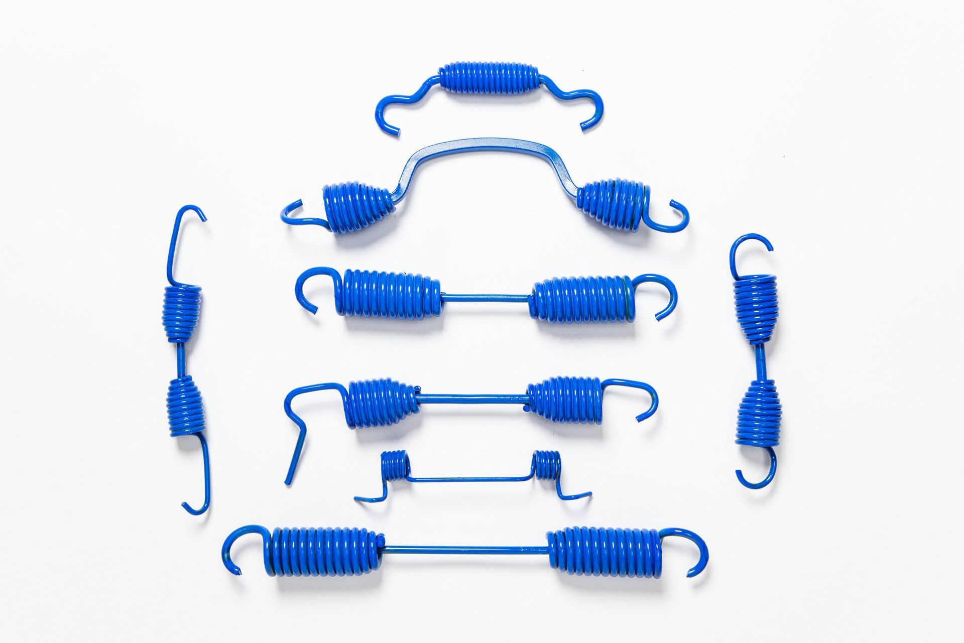 A bunch of blue springs are sitting on top of each other on a white surface.