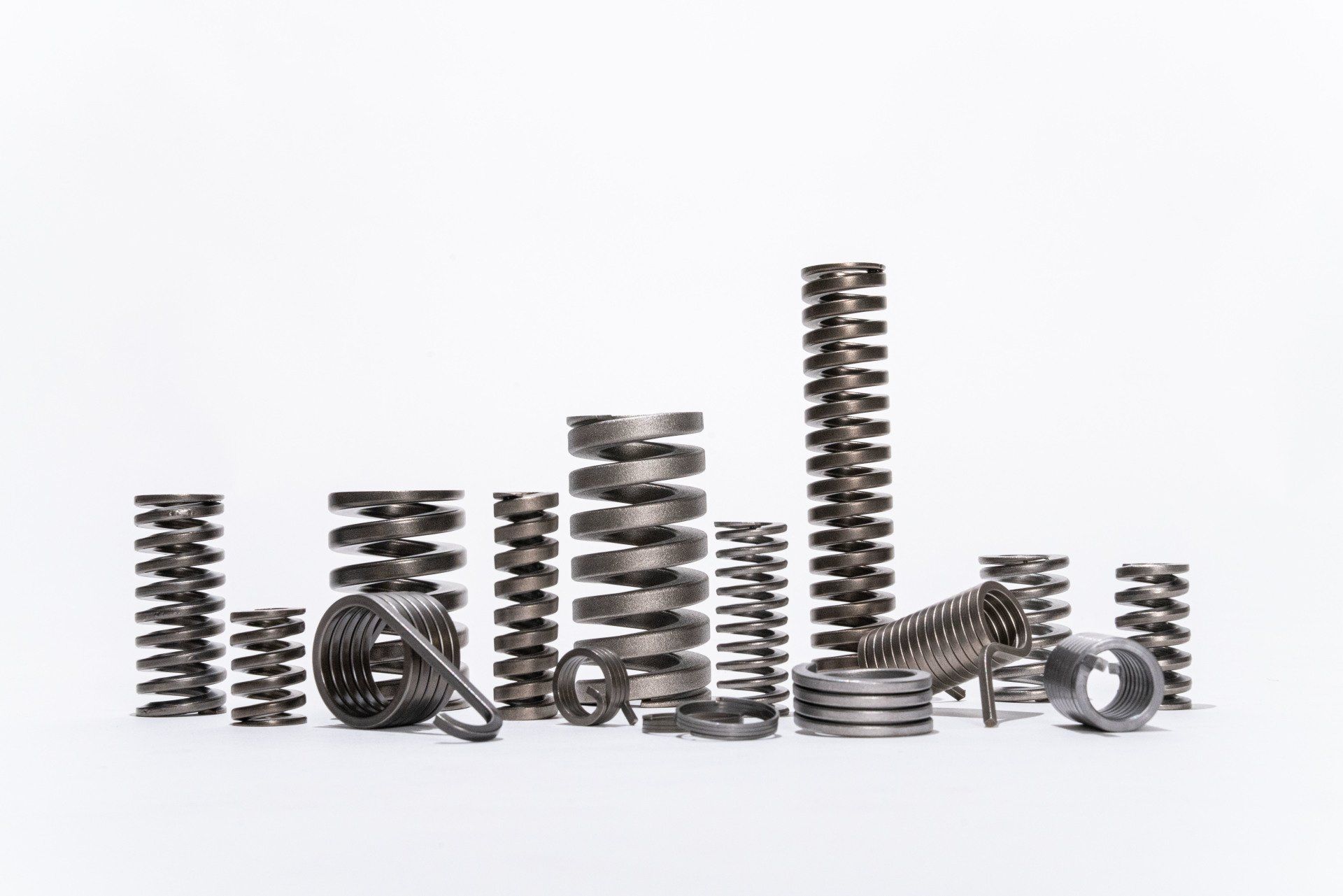 There are many different types of springs on a white background.