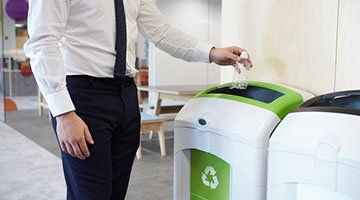 Recycling Services — Man Throwing Plastic Bottle on Bin in Taylors, SC Recycling Services — Man Throwing Plastic Bottle on Bin in Taylors, SC