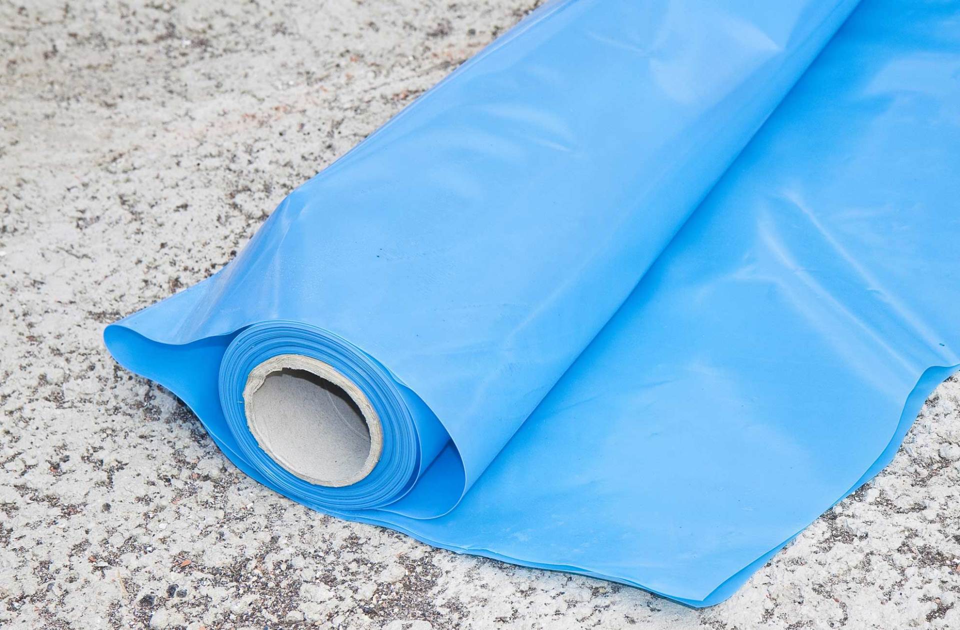 A roll of blue plastic is sitting on a marble surface.
