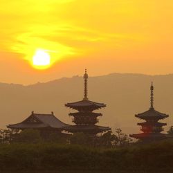 Japan Sunset Three pagodas are silhouetted against a sunset sky