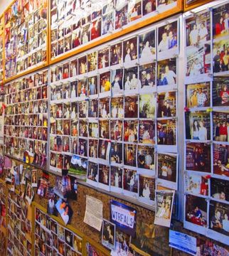 Wall covered with a grid of colorful event photos and snapshots, with signs along the bottom.