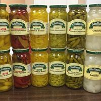 Rows of Giardiniera and other pickled vegetables in glass jars on store shelves