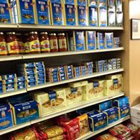 Grocery store shelf stocked with rows of blue and red boxed and canned food products