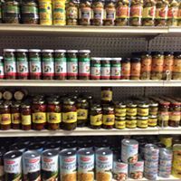 Shelves in a grocery store stocked with rows of canned goods and jars