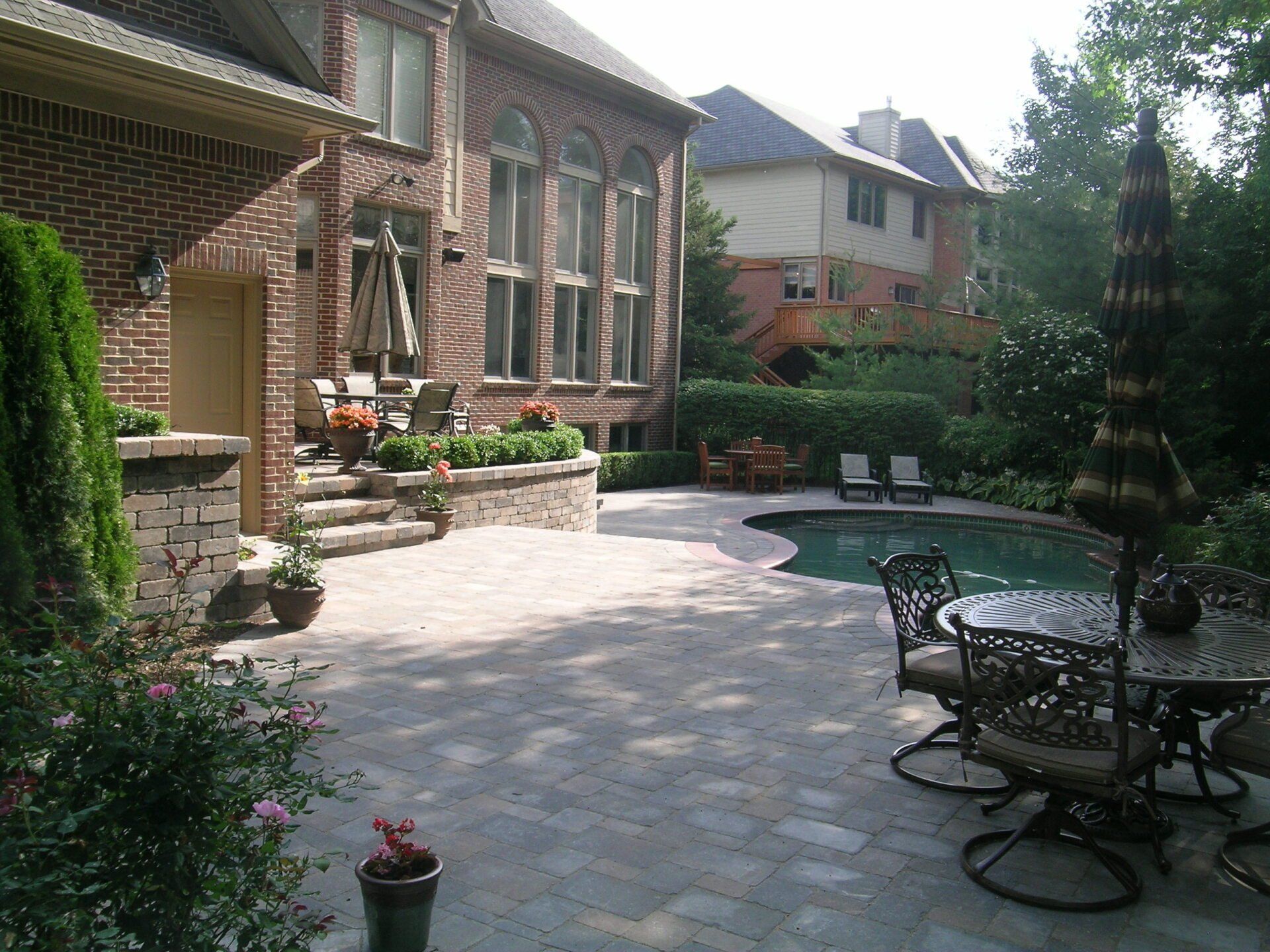 A large brick house with a large swimming pool in the backyard
